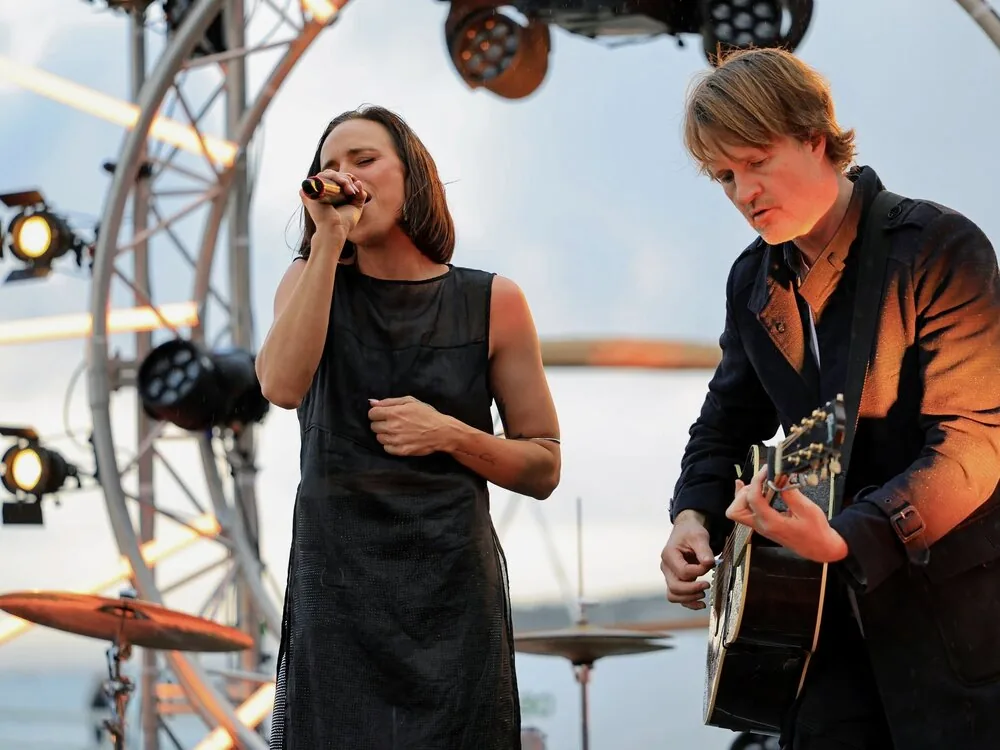 Two musicians performing on an outdoor festival stage